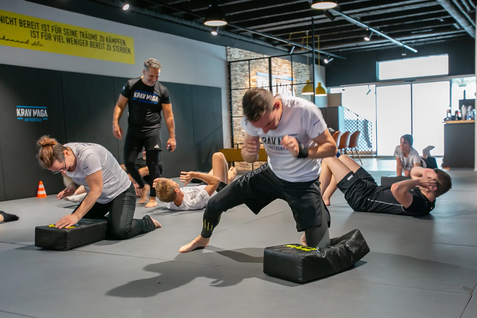 Krav Maga Teilnehmer im Gruppentraining am Schlagpolster